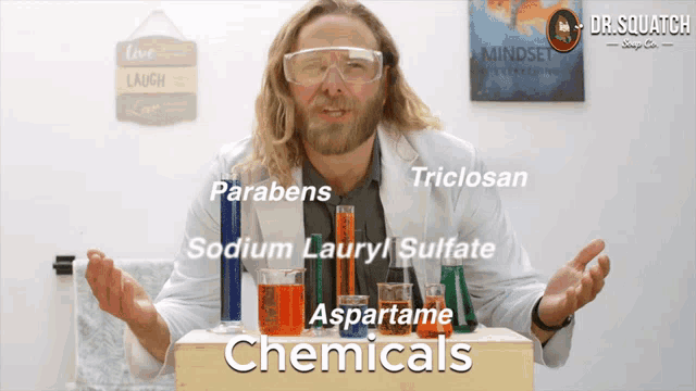 a man stands in front of a box of chemicals including parabens and triclosan