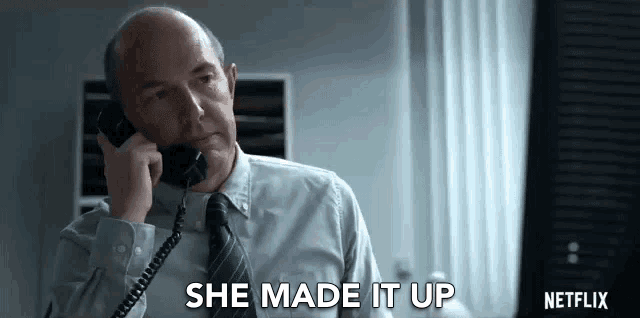 a man in a suit and tie is talking on a phone .
