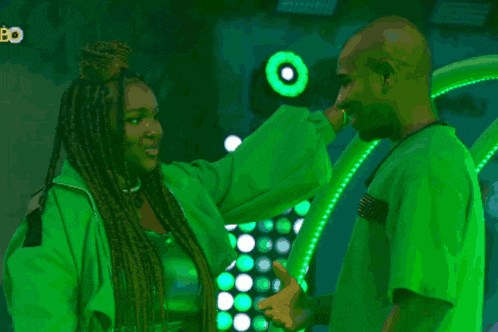 a man and a woman are standing next to each other in front of green lights and the word bo is on the bottom