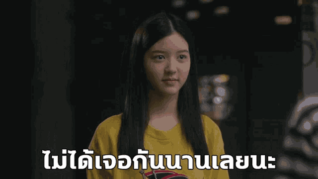 a girl wearing a yellow t-shirt with a sticker on it that says ' rolling stones ' on it