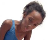 a young girl in a blue tank top is looking at the camera .