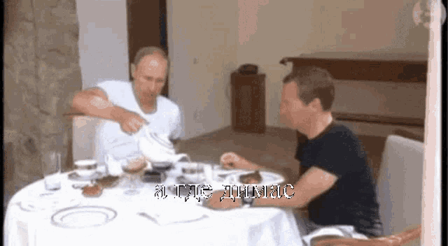 two men are sitting at a table with plates of food and a sign that says " all rights reserved "