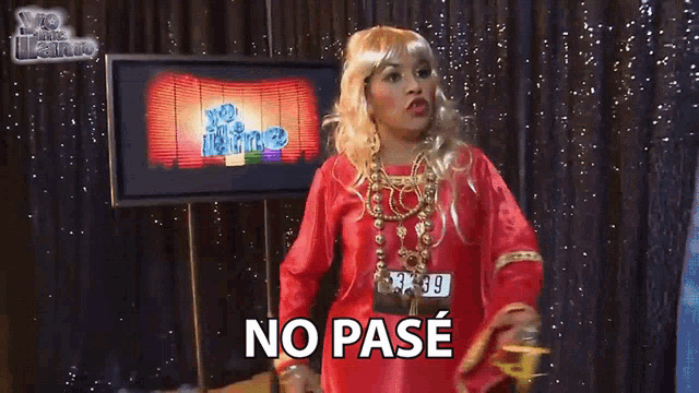 a woman in a red dress says no pase in front of a television