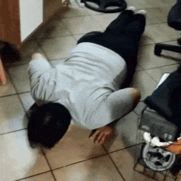 a man is laying on the floor with his head on his knees
