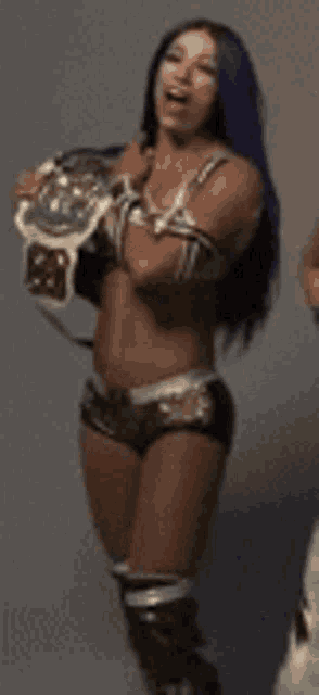 a female wrestler with blue hair is standing with her arms crossed .