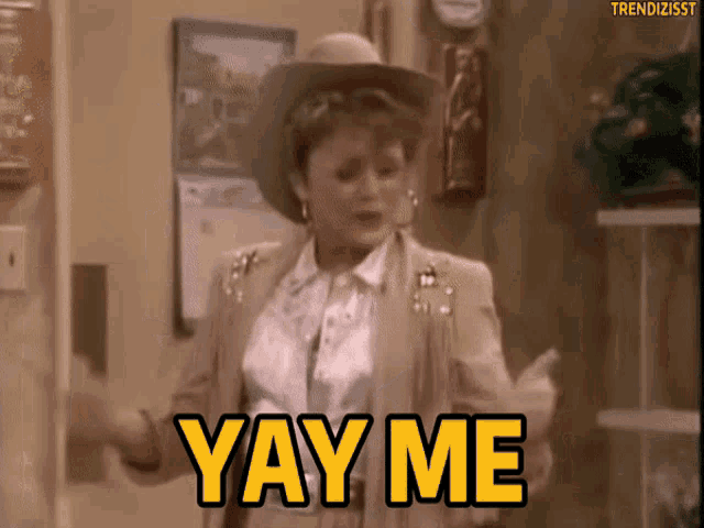 a woman in a cowboy hat is dancing and saying yay me