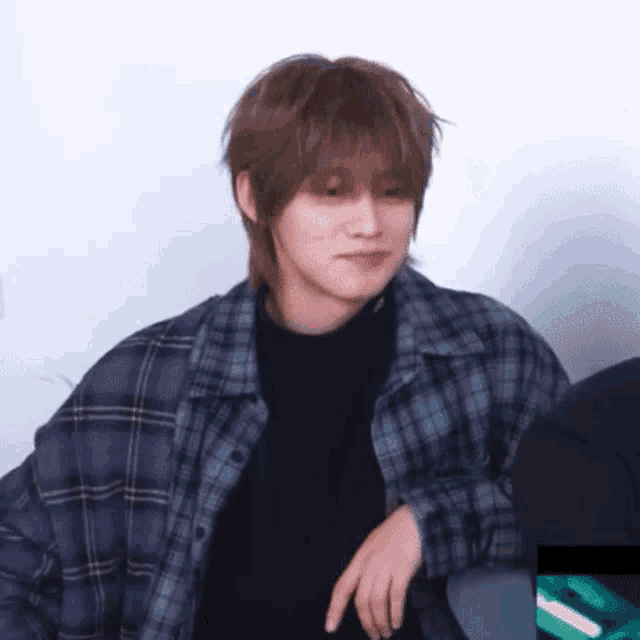 a man wearing a plaid shirt and a black sweater