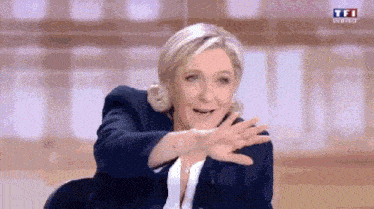 a woman in a suit is making a funny face while sitting on a stage .