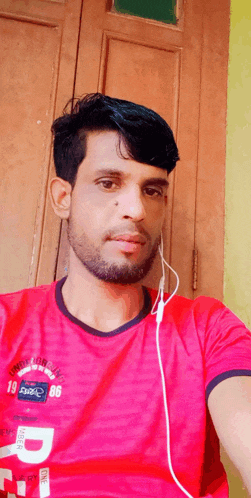 a man wearing a red shirt with the number 86 on it takes a selfie