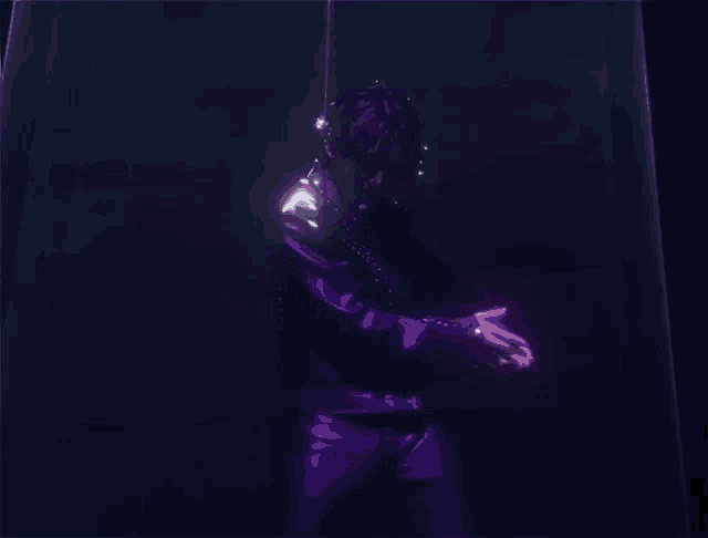 a man in a purple jacket and pants is standing in a dark room