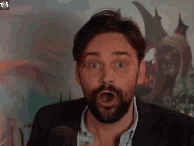 a man with a beard is saying " holy shit "