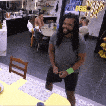 a man with long hair and a beard is standing in a room with a sign that says vip