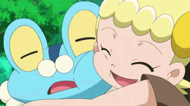 a girl is hugging a blue frog with a yellow face