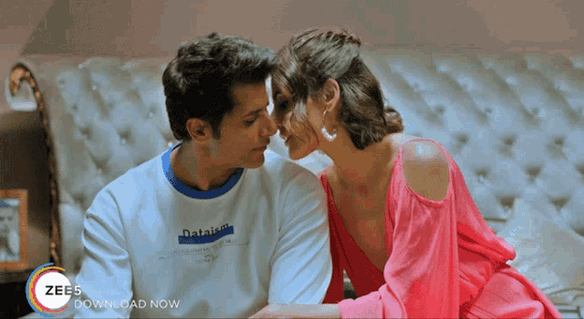a man and a woman are kissing in front of a zee advertisement