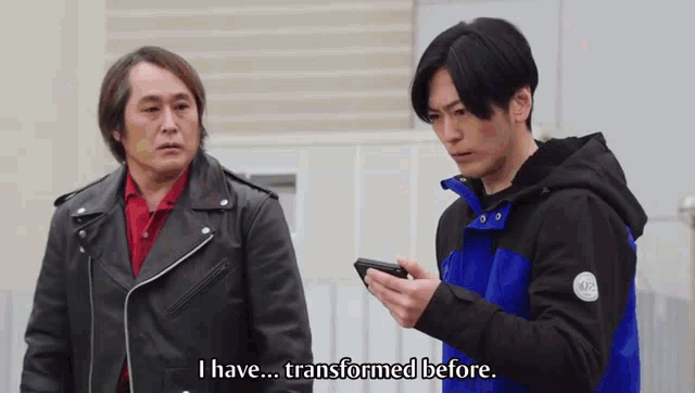 two men are standing next to each other and one is holding a cell phone and the other is saying i have transformed before ..
