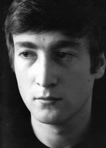 a close up of a young man 's face with a black background