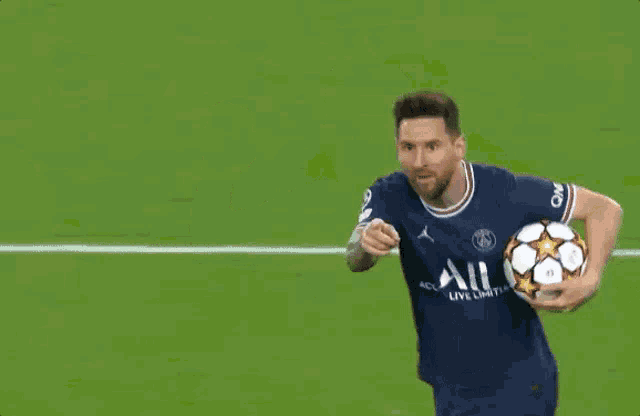 a soccer player is holding a soccer ball and giving a high five to another player .