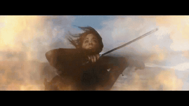 a woman is flying through the air holding a sword
