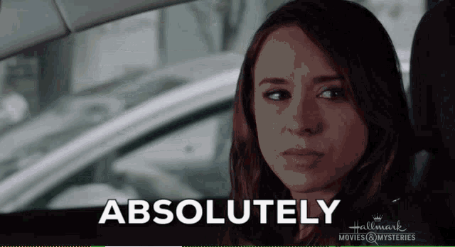 a woman is sitting in a car with the word absolutely written on the screen