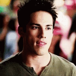 a man in a green shirt is sticking his tongue out while standing in front of a crowd .