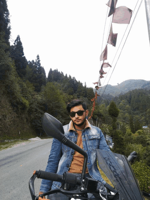 a man wearing sunglasses is sitting on a motorcycle on a road