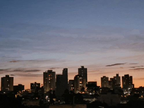 a city skyline at sunset with a blue sky