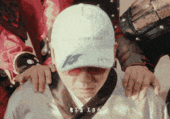 a man wearing a white hat with the number 10 on it is surrounded by people