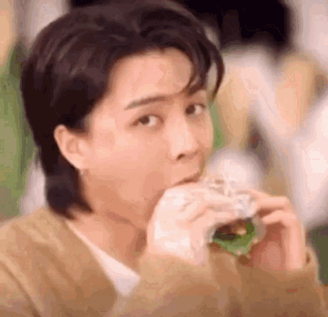 a woman is eating a hamburger in a restaurant .