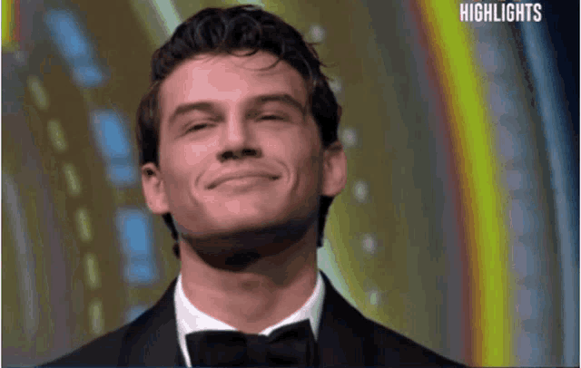 a man in a tuxedo is smiling and the words highlights are visible in the background