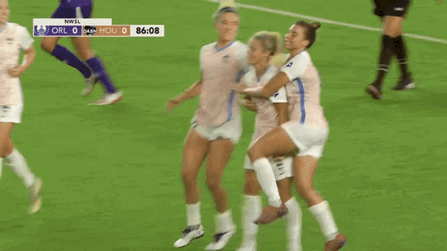 a group of female soccer players are celebrating a goal during a game
