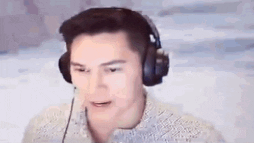 a man wearing headphones and a microphone is talking into a microphone .