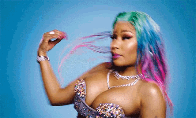 a woman with colorful hair is wearing a very revealing top and a necklace .