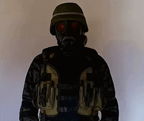 a man wearing a gas mask and a helmet has a vest that says ' tactical vest ' on it
