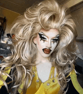 a drag queen wearing a yellow top and wig