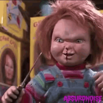 a chucky doll is holding a pair of scissors and a screwdriver .