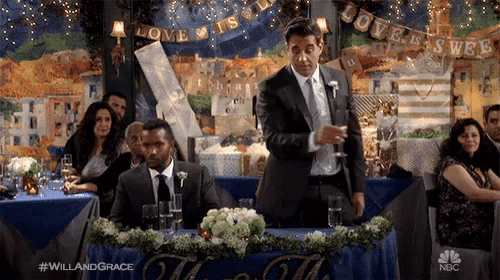 a man in a suit is giving a speech at a wedding