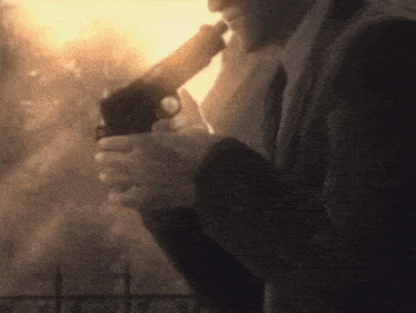 a man in a suit and tie is holding a gun .