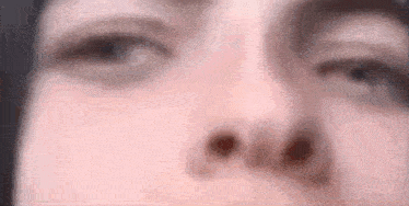 a close up of a person 's face with a blurred background .