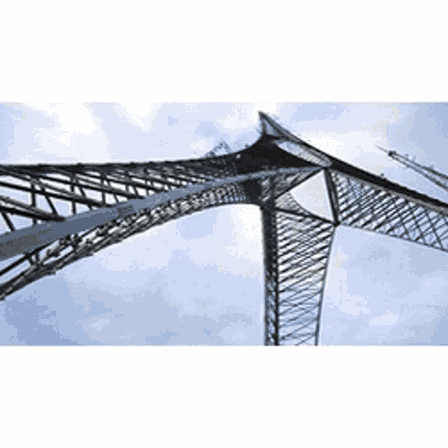 looking up at a very tall metal structure with a blue sky in the background
