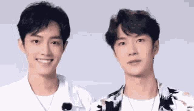 two men are standing next to each other and smiling .