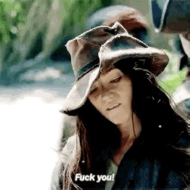 a woman wearing a cowboy hat is talking to a man .