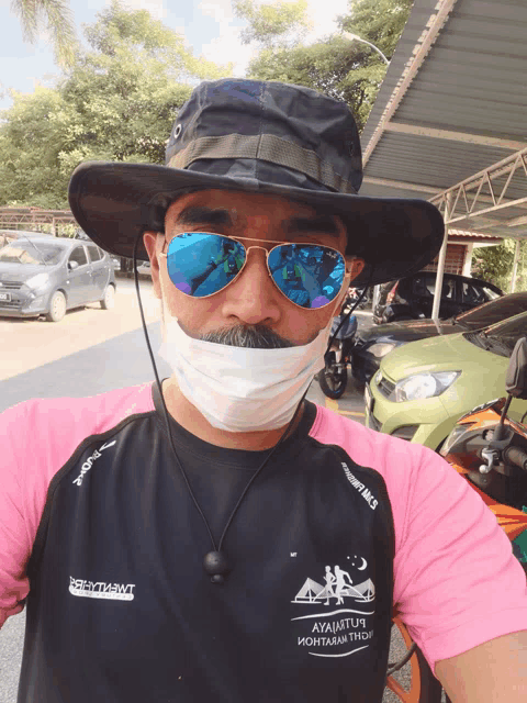 a man wearing a hat and sunglasses is wearing a t-shirt that says " ayajatim "