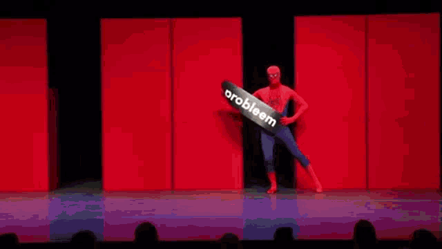 a man in a spiderman costume is holding a sign that says probleem .