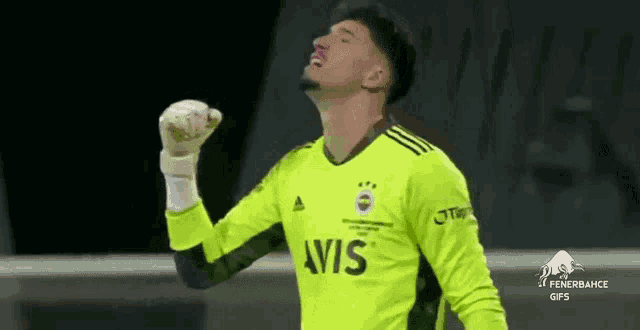 a soccer player wearing a yellow jersey with the word avis on it is celebrating a goal .