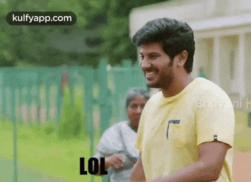 a man in a yellow shirt is standing in front of a woman and says lol .