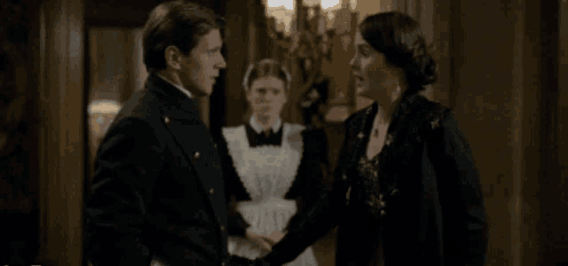 a man and a woman are standing next to each other in a dark room