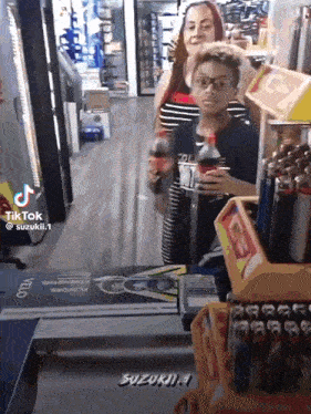 a young boy is holding a bottle of coke in a store .