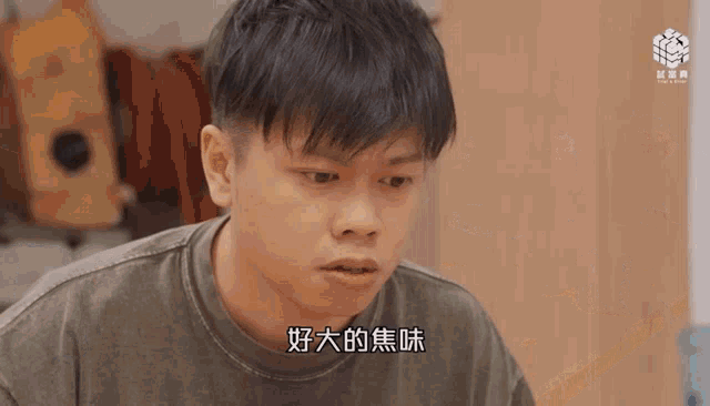 a man with chinese writing on his shirt looks at something