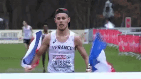 a man in a france tank top holds a flag