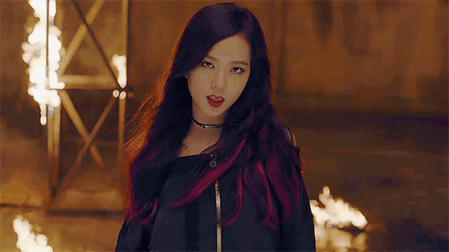 a woman with purple and red hair is wearing a choker around her neck
